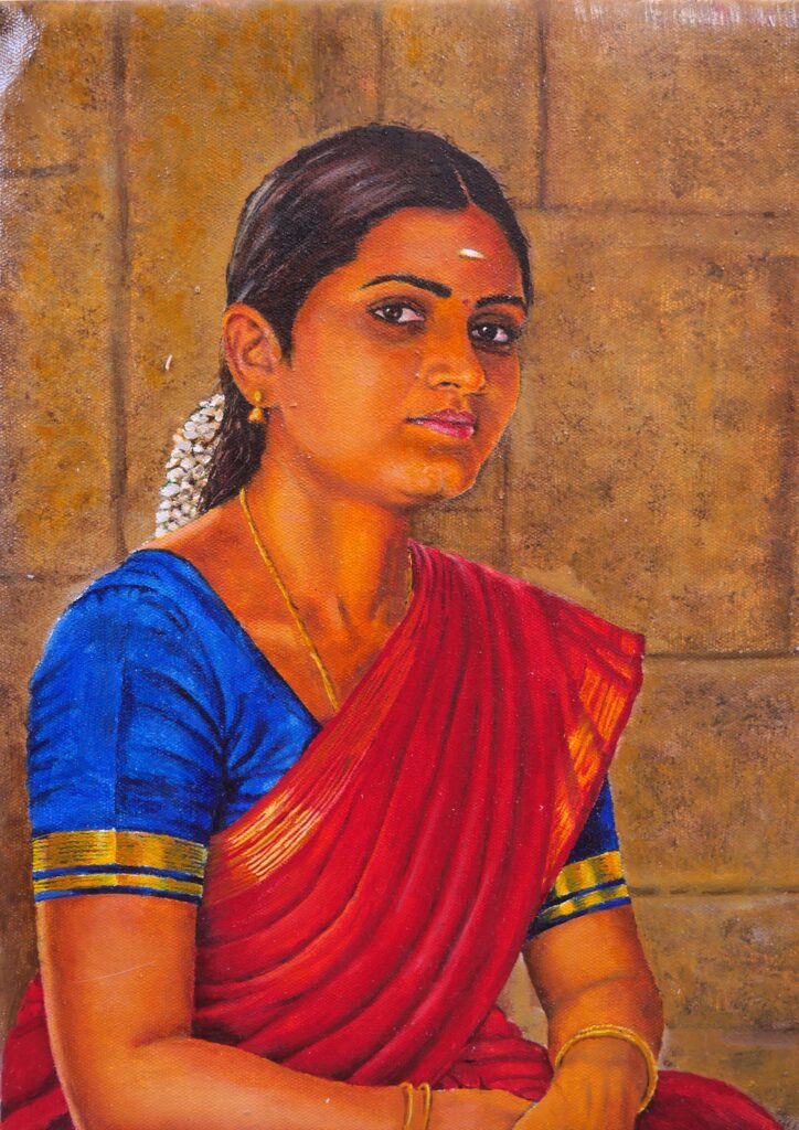 Traditional Tamil woman wearing a red saree and jasmine flowers